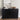 Black ribbed sideboard with decorative items against a white wall