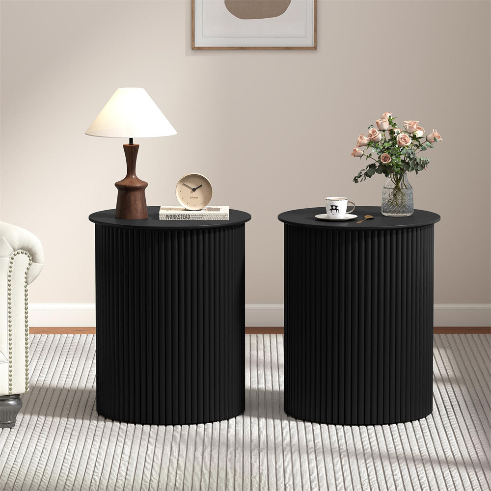 Two black side tables with decorative items in a room setting.