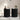 Two black side tables with decorative items in a room setting.