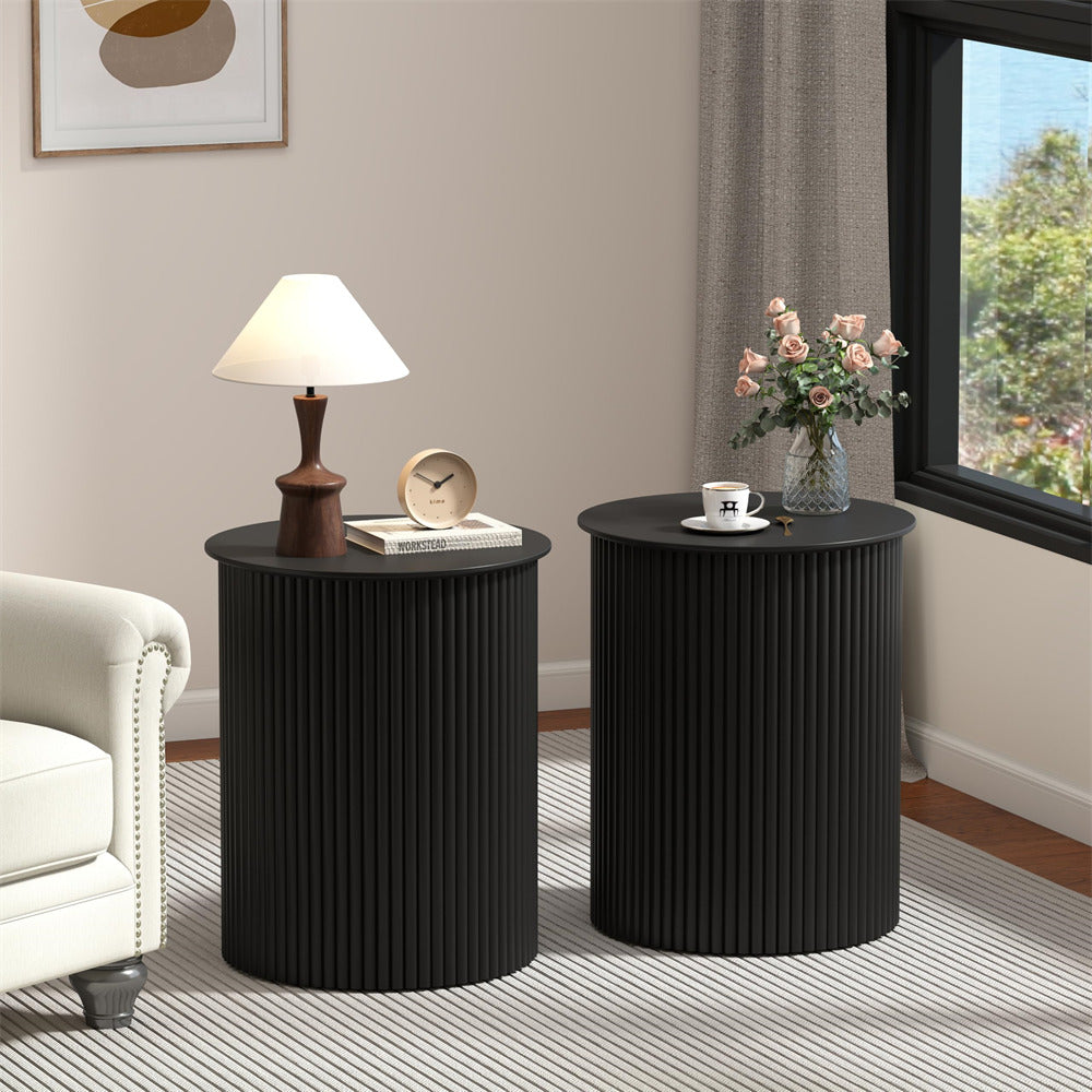 Two black side tables with decorative items in a living room setting.