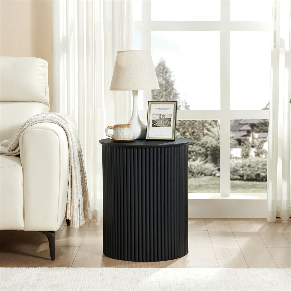 Black side table with lamp and decor in a living room setting