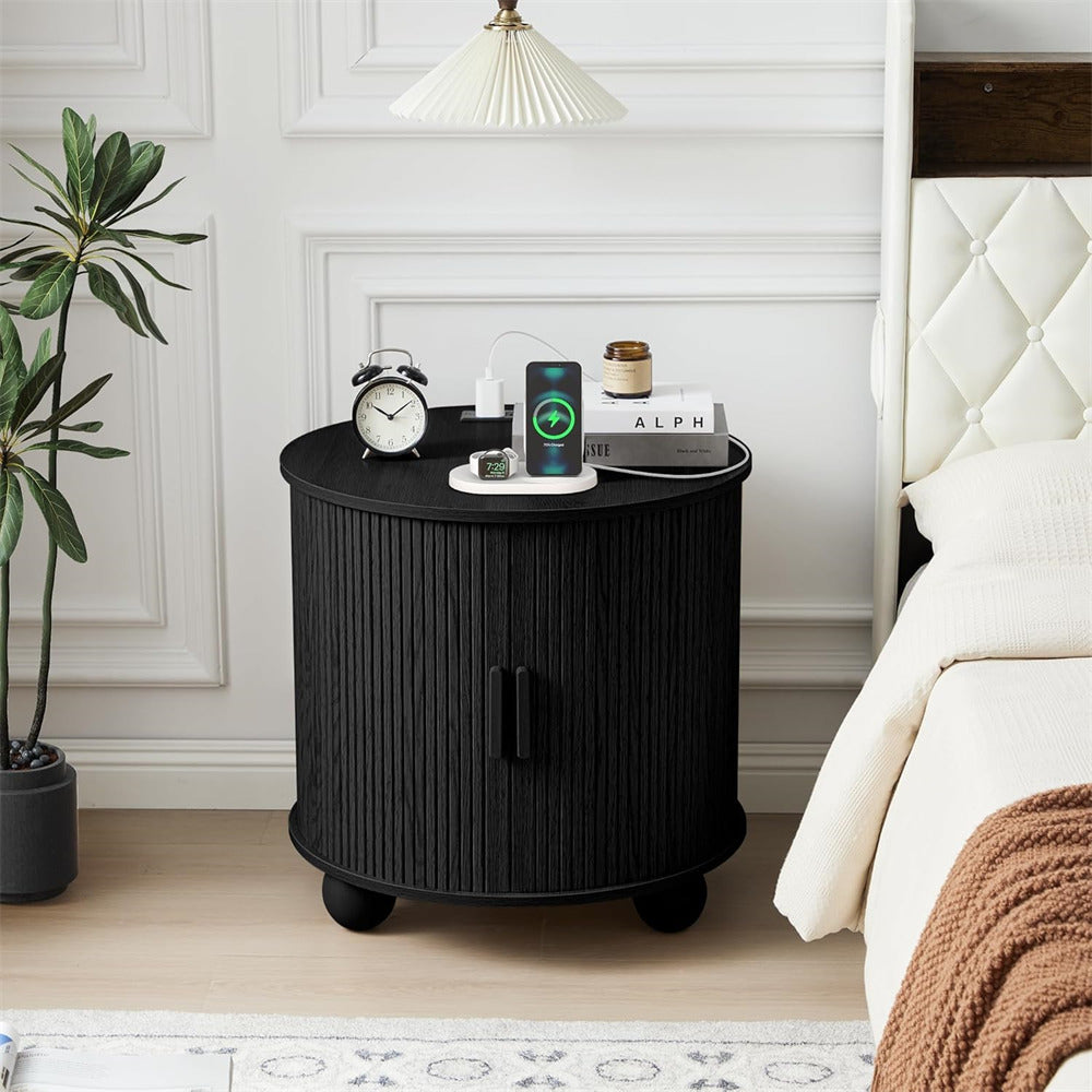 Black round nightstand with various items in a bedroom setting