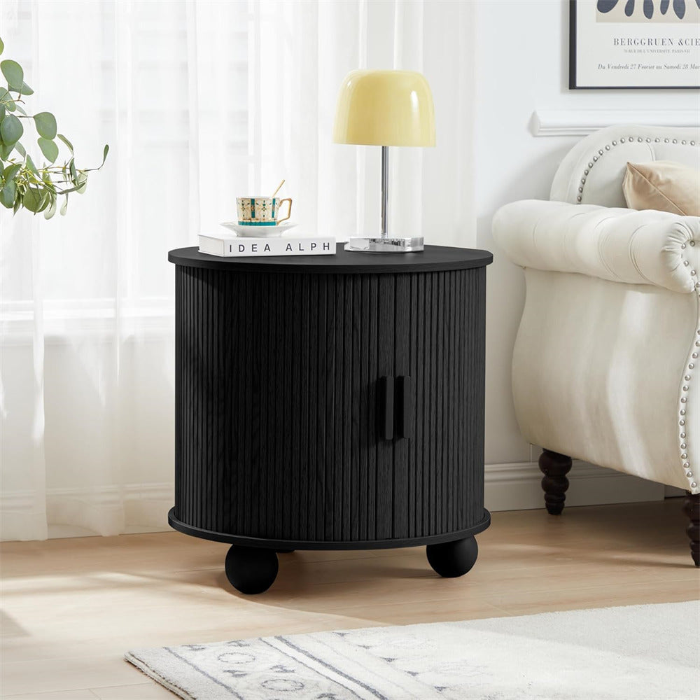 Black side table with a lamp and books in a living room setting