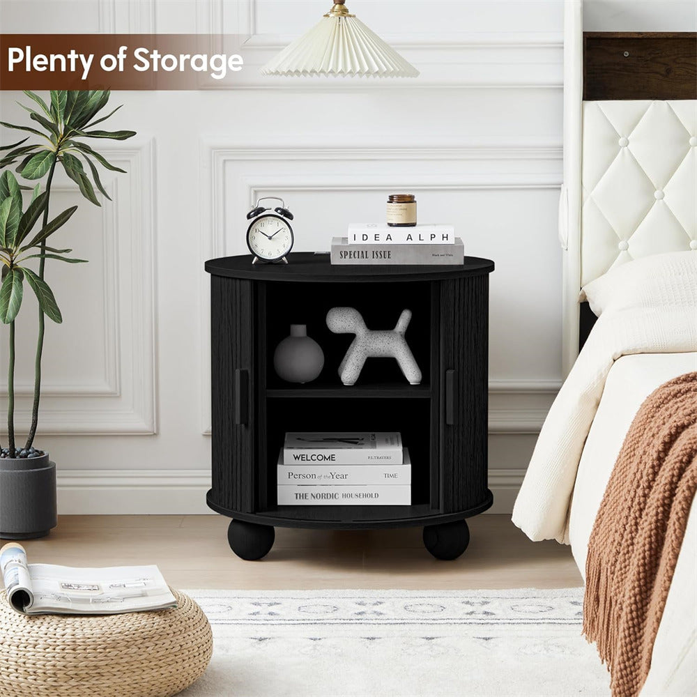 Black storage nightstand with books and decor items in a bedroom setting.