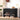 Black shoe storage bench with shoes underneath, against a white wall.