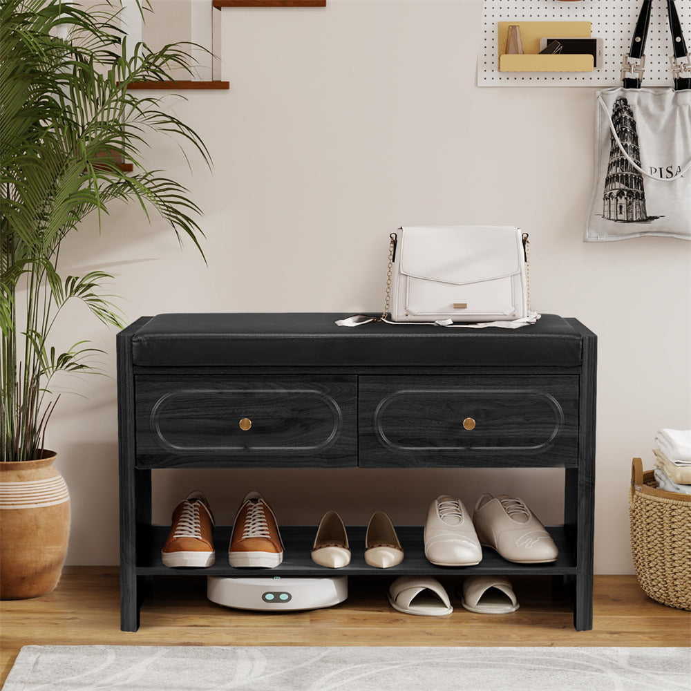Black shoe cabinet with shoes on a wooden floor, plant to the left