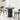 Black round table with two chairs in a room with white curtains and a rug.