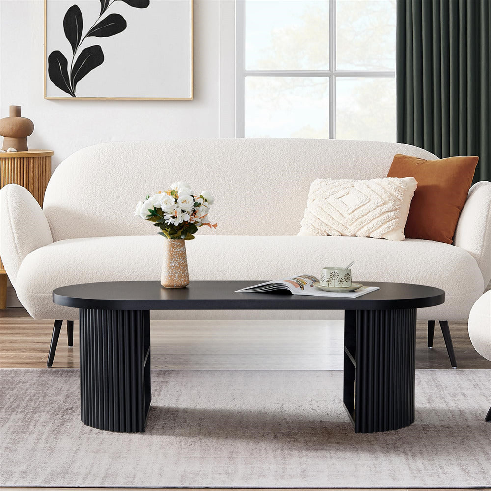Modern living room with a white sofa, black coffee table, and decorative elements.