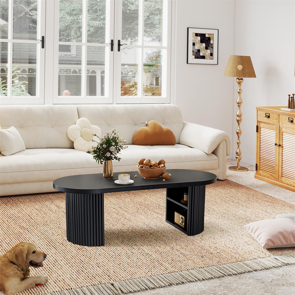 Living room with a white sofa, black coffee table, and decorative items.