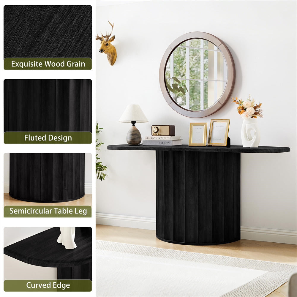 Black console table with fluted design and semicircular leg in a room setting.