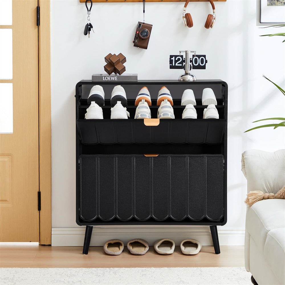 Black shoe cabinet with shoes inside, placed in a room with a white wall and wooden floor.
