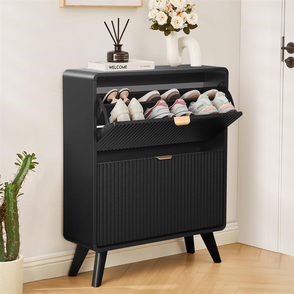Black shoe cabinet with shoes inside, placed against a white wall with decorative items.