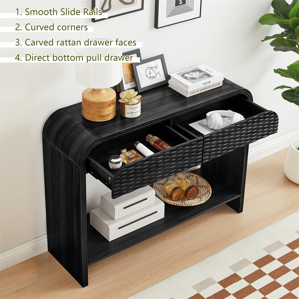 Black console table with carved rattan drawer faces in a room setting.