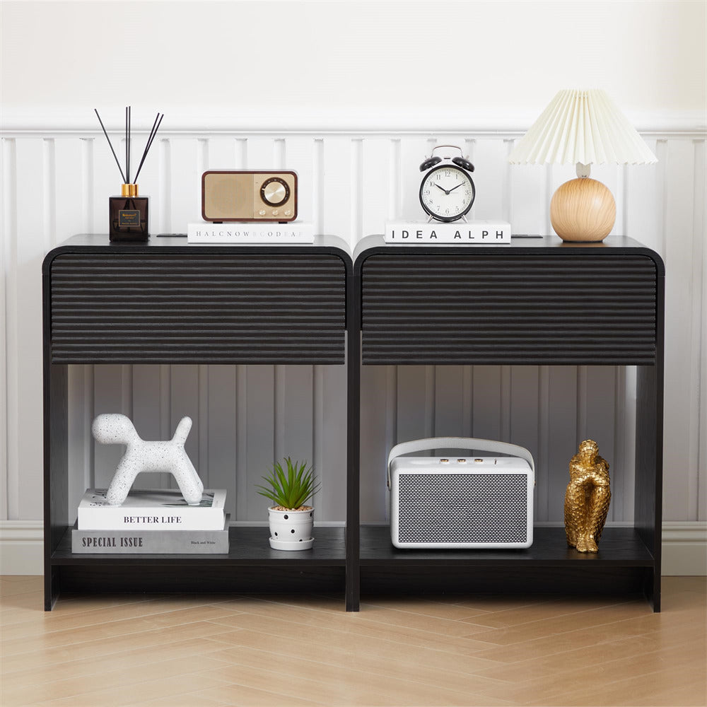 Black side table with decorative items against a white wall