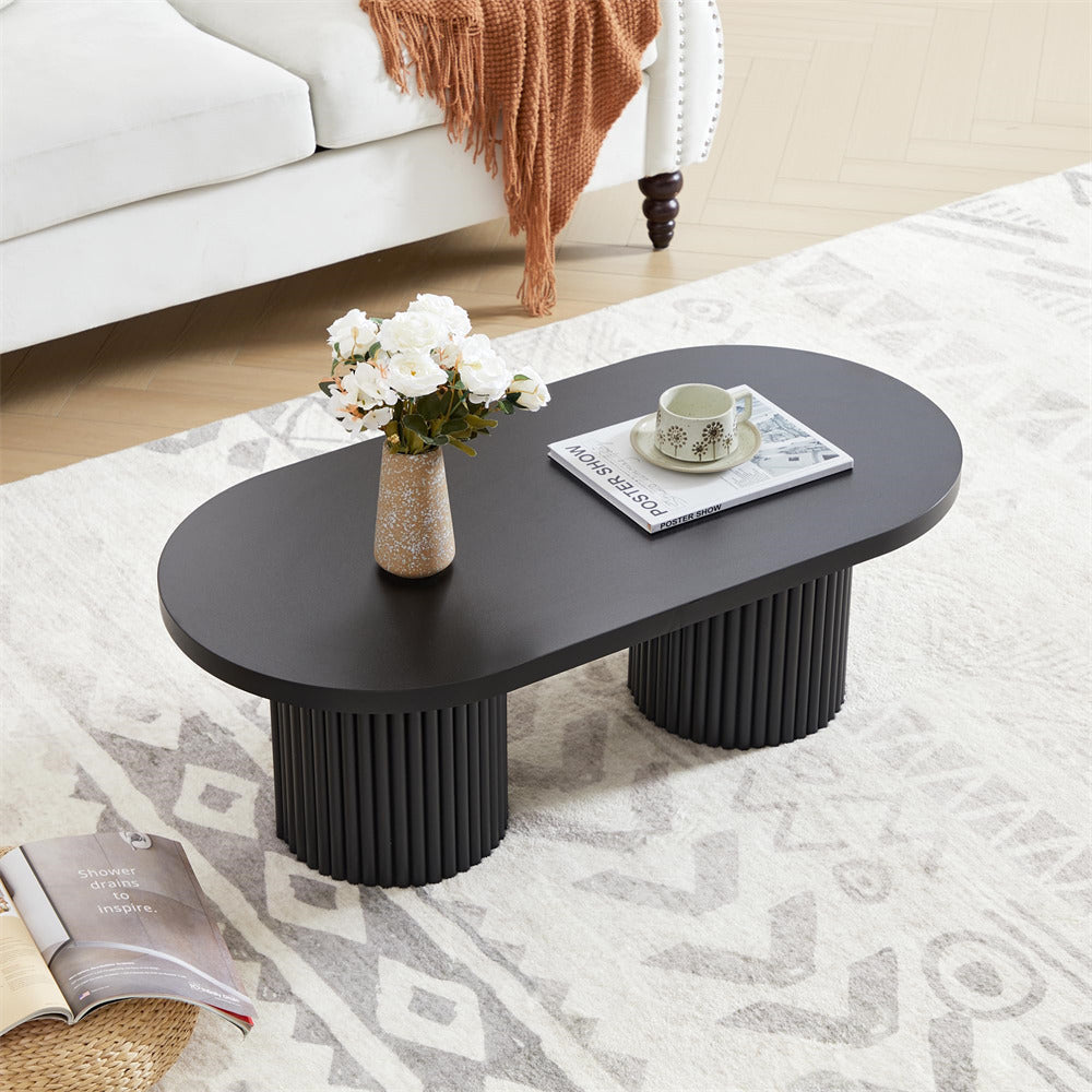 Black coffee table with decorative items in a living room setting