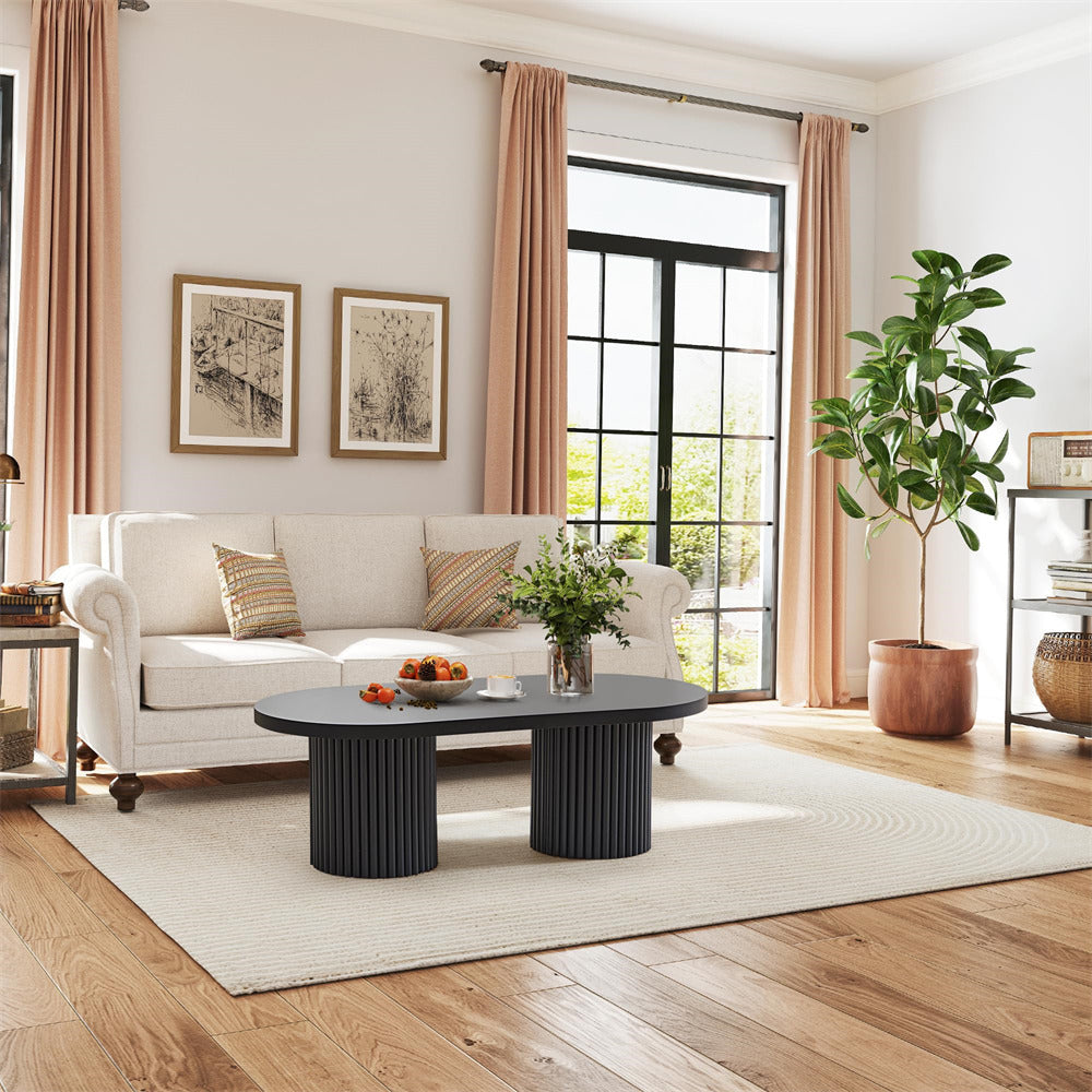 Living room with a white sofa, black coffee table, and decorative elements.