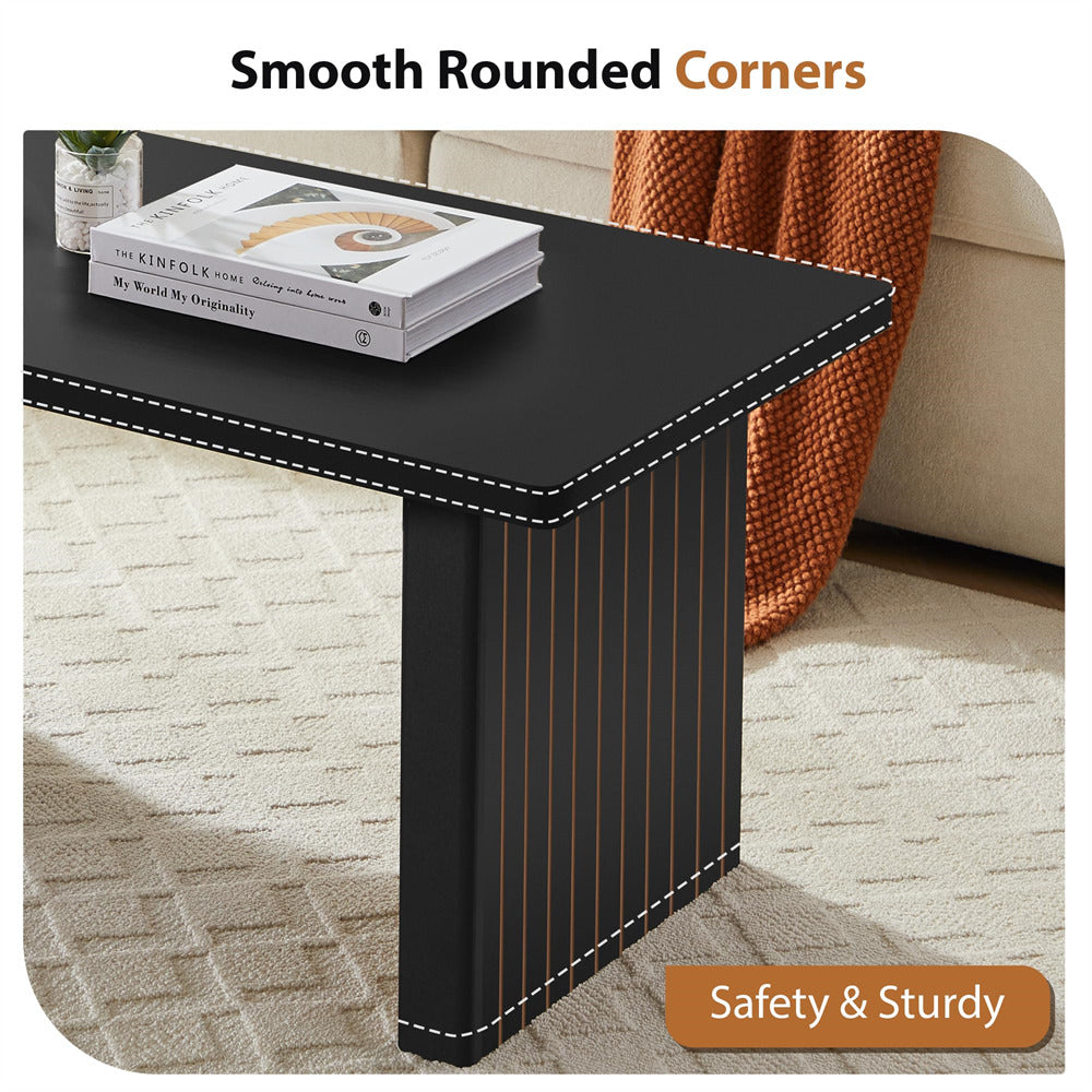 Black side table with rounded corners in a living room setting