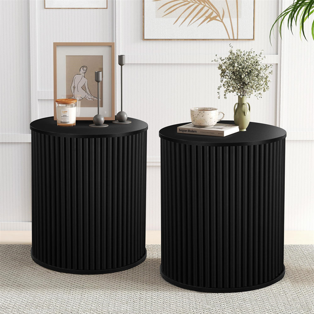 Two black side tables with decorative items in a room setting.