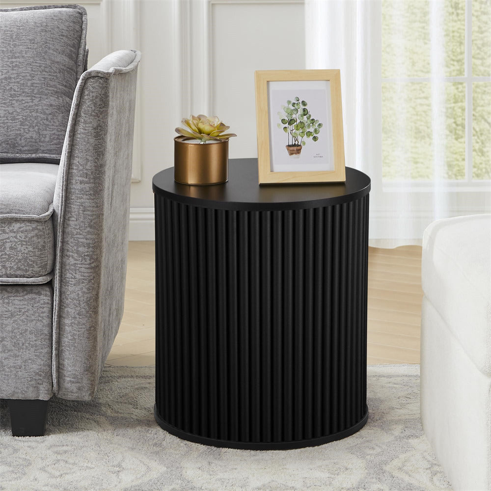 Black ribbed side table with decorative items in a living room setting
