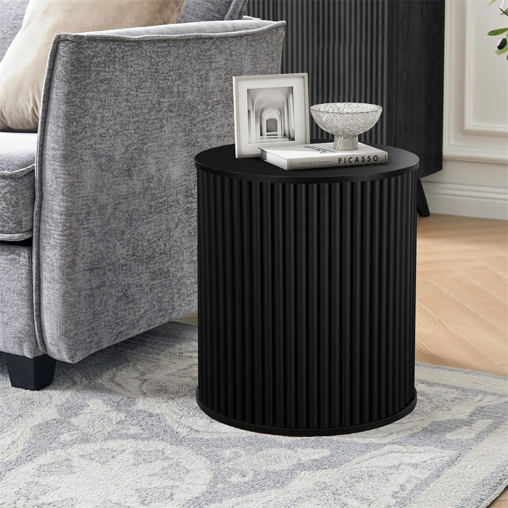 Black ribbed side table with decorative items in a living room setting.