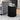 Black ribbed side table with decorative items in a living room setting.