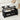 Black lift-top coffee table with items on top in a living room setting