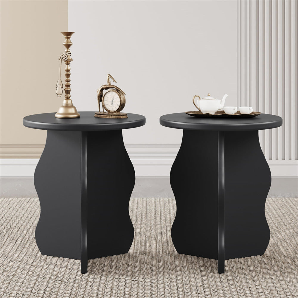 Two black side tables with decorative items on a neutral background