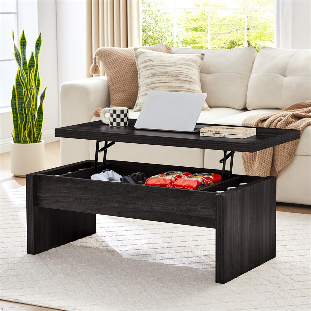 Black lift-top coffee table in a living room setting with a laptop, mug, and books on top.