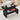 Black coffee table with open storage compartments in a living room setting.