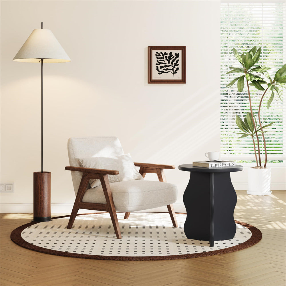Modern living room with a white armchair, black table, and decorative elements.