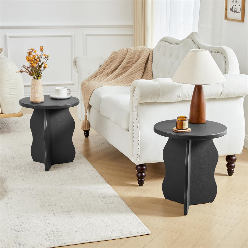 Living room with a white sofa, black side tables, and decorative items.