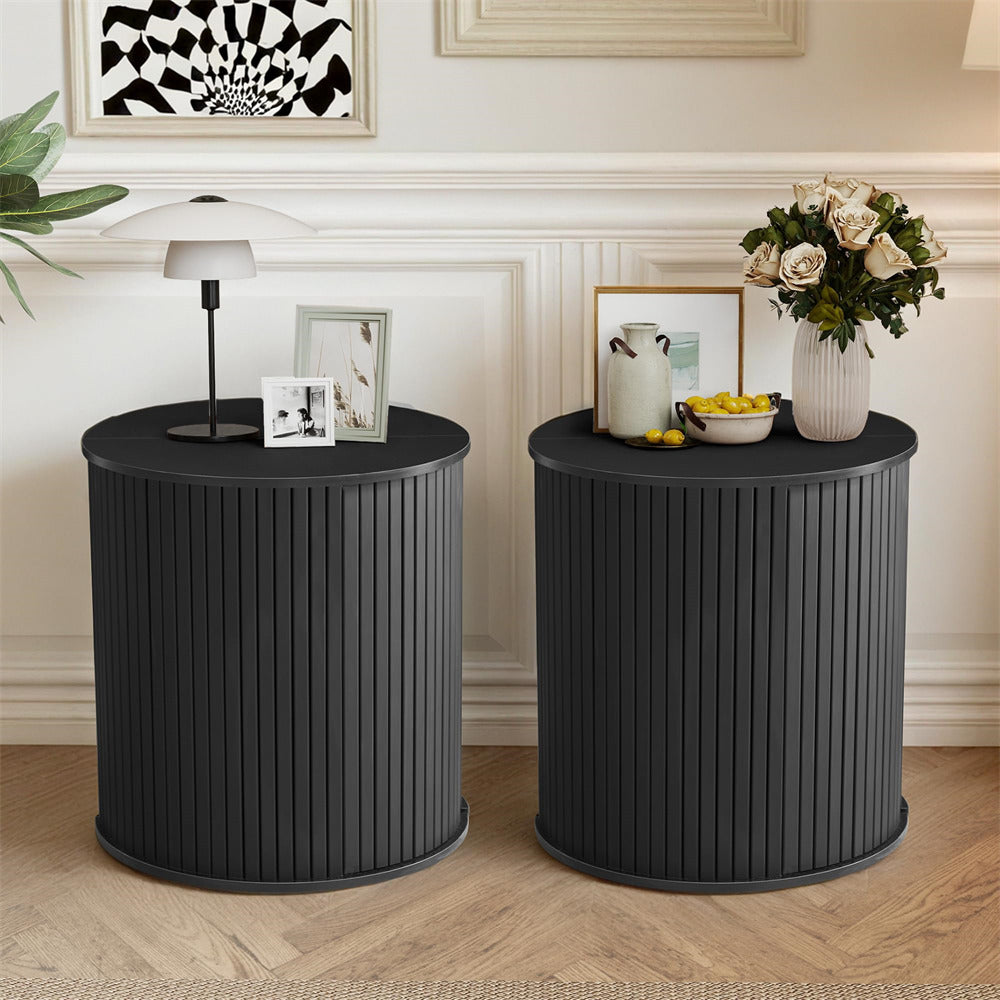Two black side tables with decorative items in a room with framed artwork on the wall.