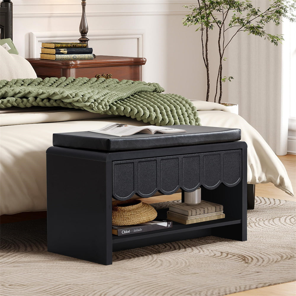 Black storage bench in a bedroom with a bed and green blanket.