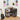Vinyl record storage unit with records and a guitar in a room setting.