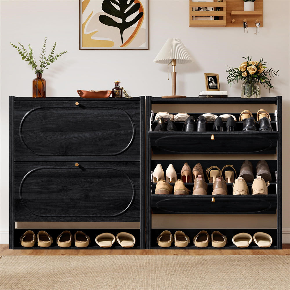 Black shoe cabinet with shoes on a wooden floor, decorated room in the background
