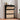 Black shoe cabinet with beige fabric doors in a room setting.