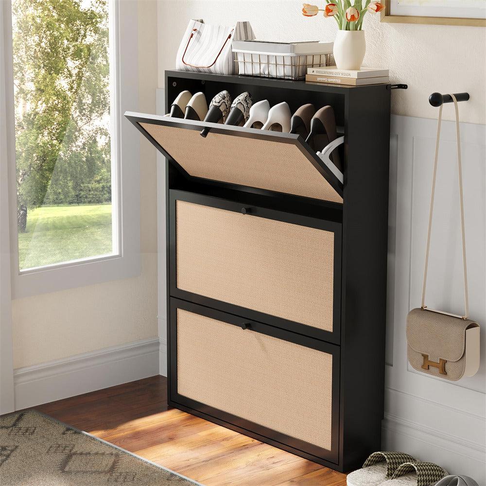 Black shoe cabinet with open door revealing shoes, next to a window with a view of greenery.