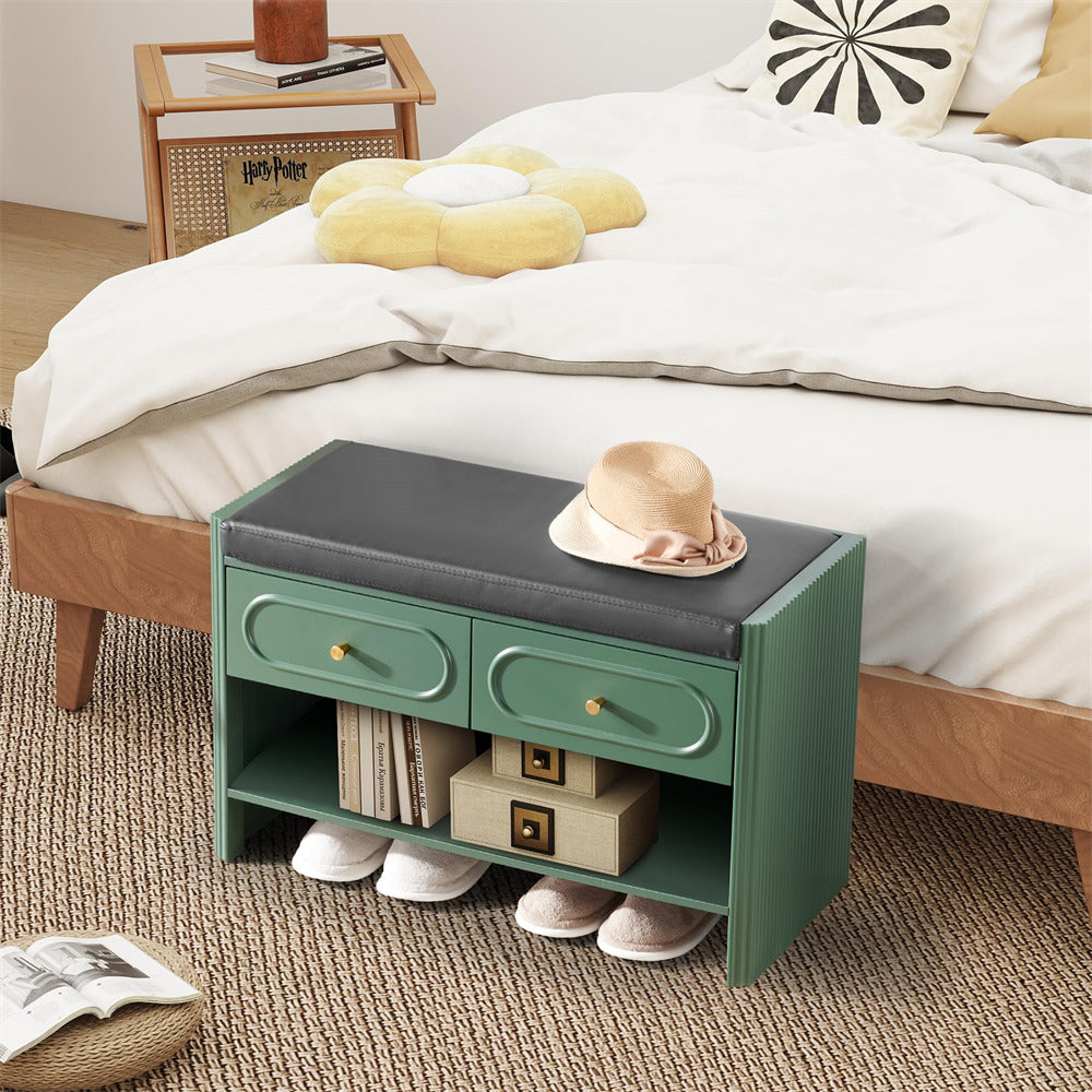 Green bench with storage drawers next to a bed with white bedding and decorative pillows.