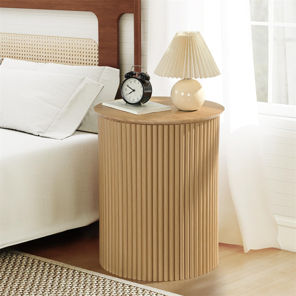 Wooden side table with lamp and clock next to a bed in a bedroom
