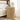 Wooden side table with lamp and clock next to a bed in a bedroom