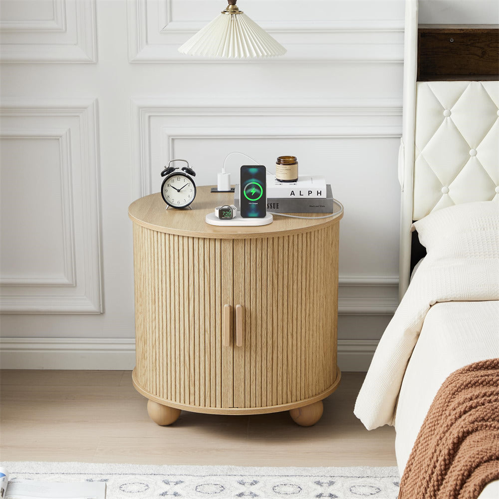 Round wooden nightstand with electronic devices in a bedroom setting