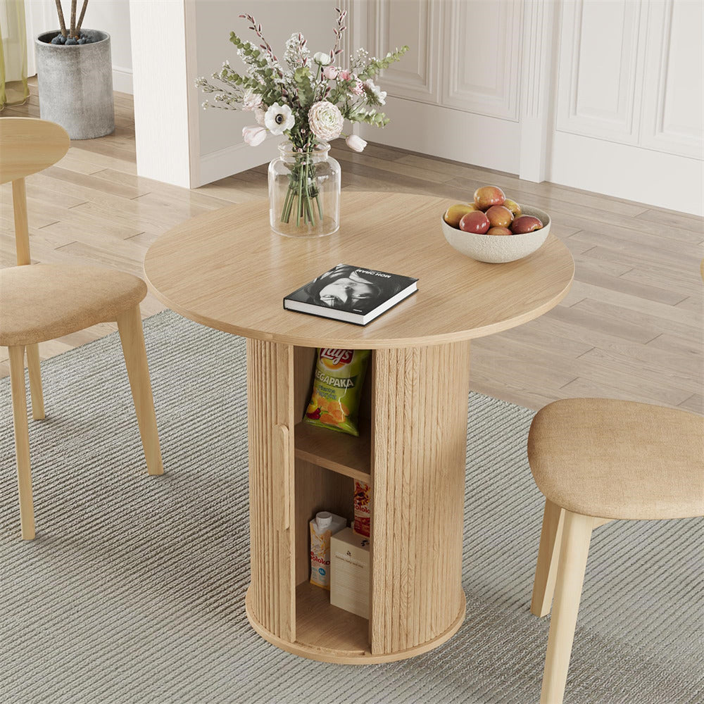 Round wooden table with shelves, fruit bowl, and flowers in a room setting.
