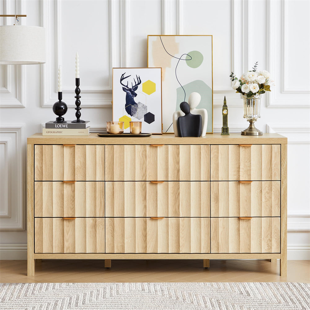 Wooden dresser with decorative items in a room with white paneled walls.