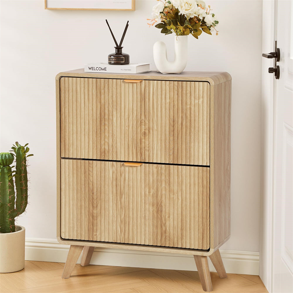 Wooden cabinet with two doors on a wooden floor, decorated with a plant and vase.