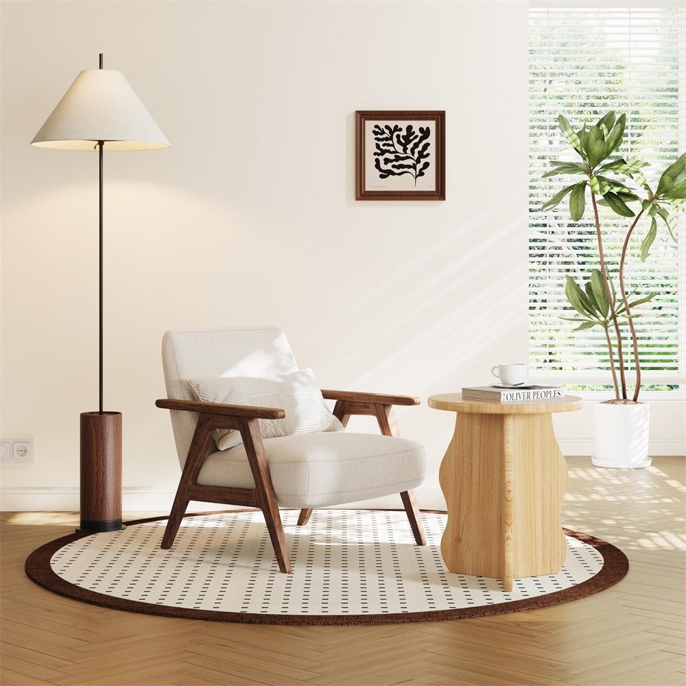Modern living room with a white armchair, wooden floor lamp, and round rug.