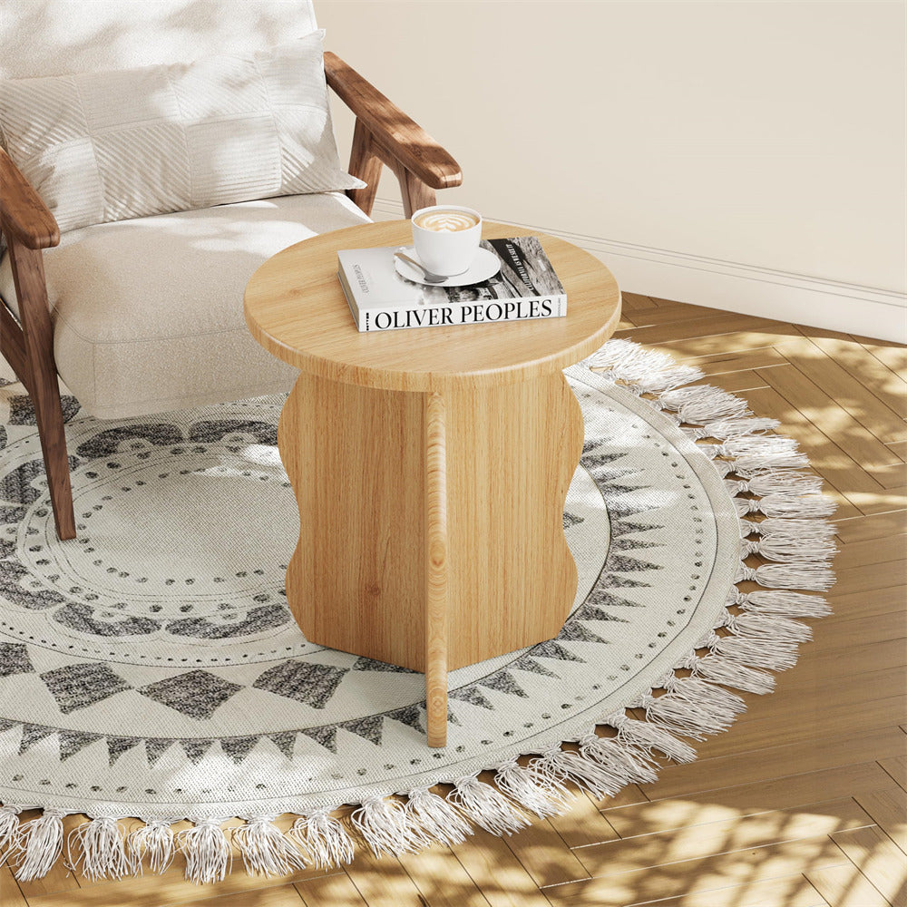 Wooden side table with a cup and book on a patterned rug in a living room.