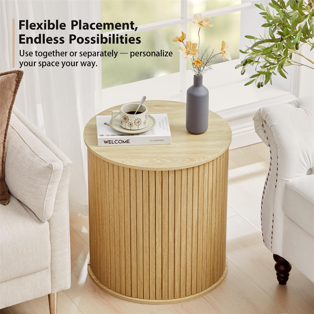 Round wooden side table with a vase and books in a living room setting.