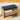 Wooden shoe bench with black cushion and open drawer on a wooden floor.