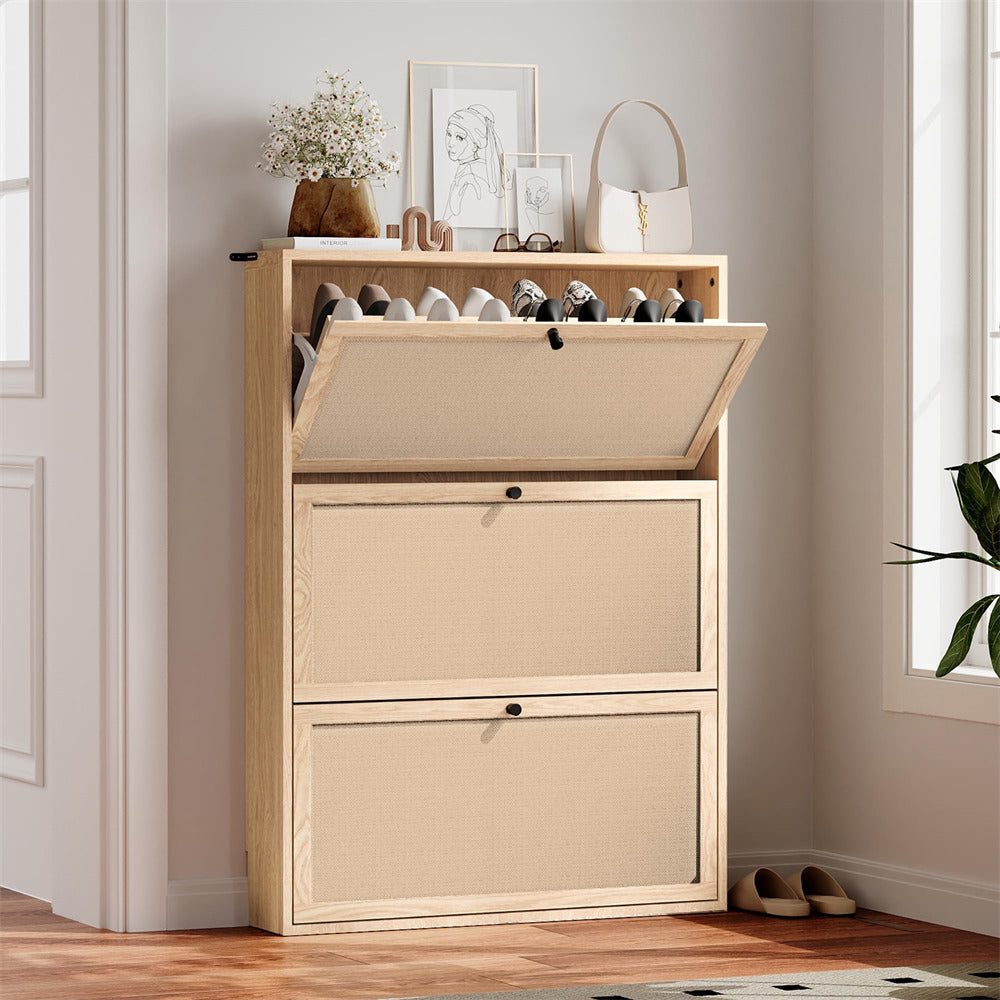 Beige shoe cabinet with open door revealing shoes, placed in a room with a window and plant.