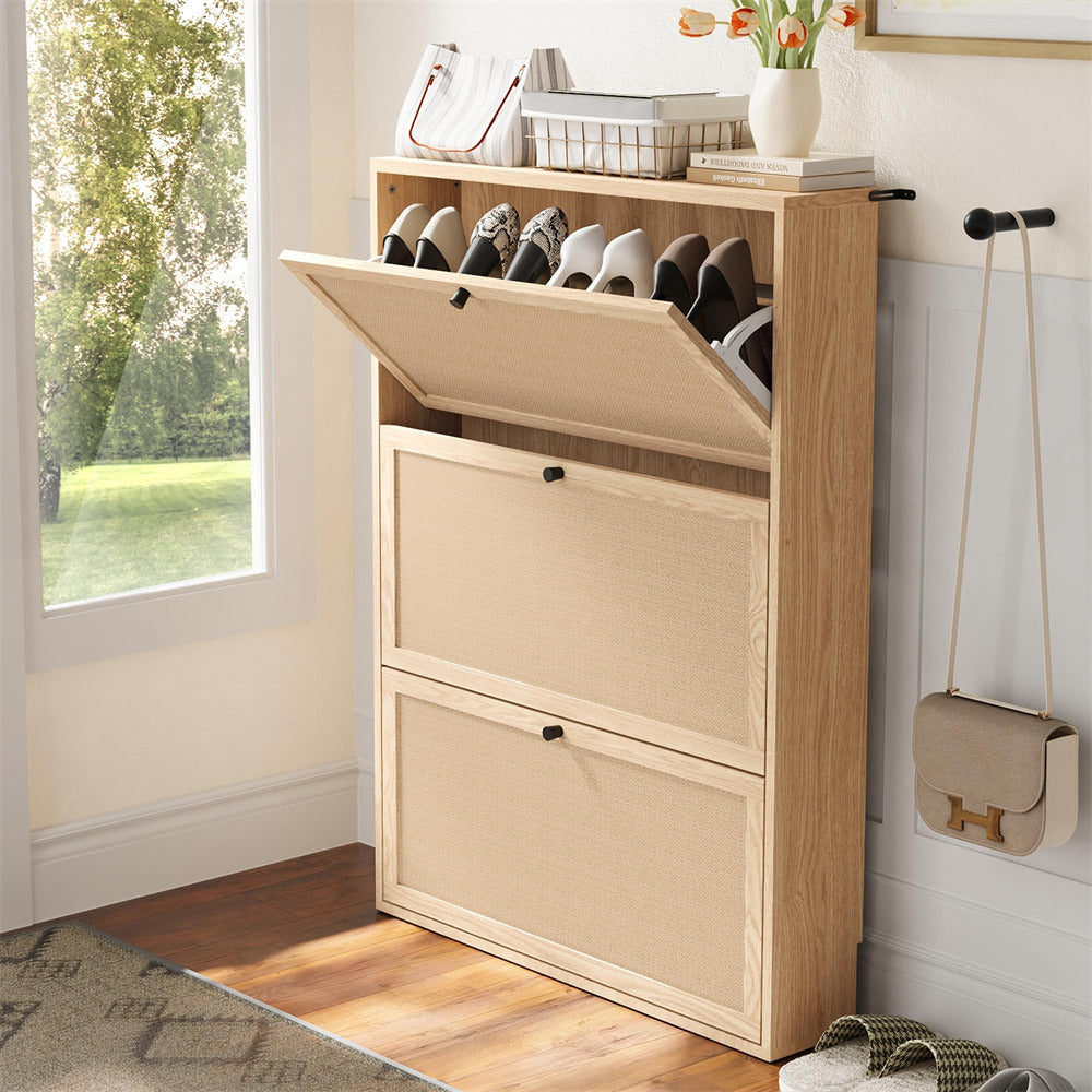 Wooden shoe cabinet with open lid showing shoes, next to a window with greenery outside.